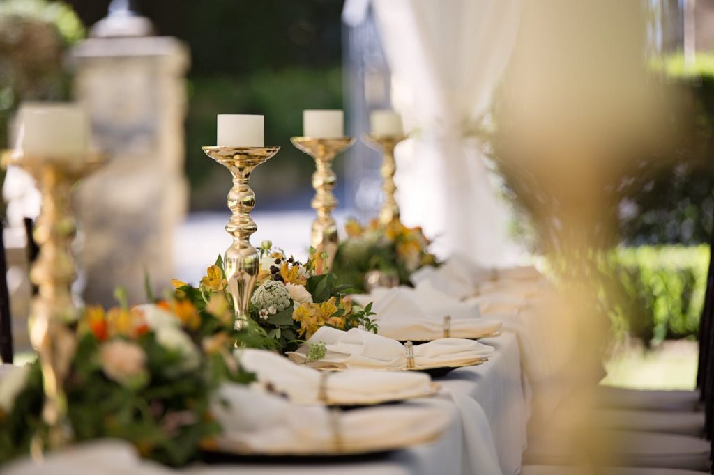 pexels photo 1128783 Luxurious outdoor wedding table setting with flowers and candlesticks.